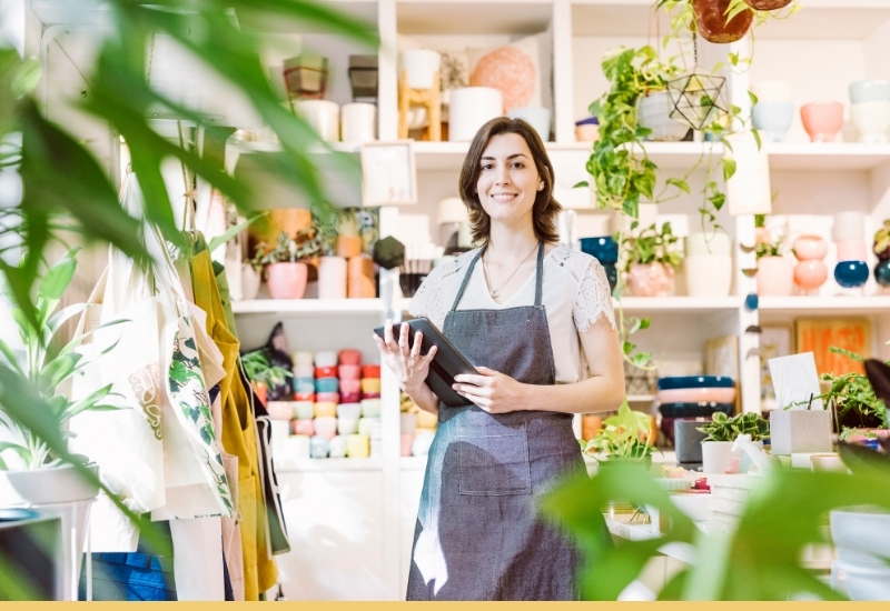Small business owner holding a tablet in her shop