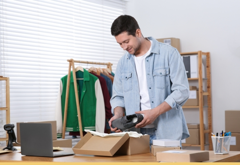 Small business owner packing shoes into a box